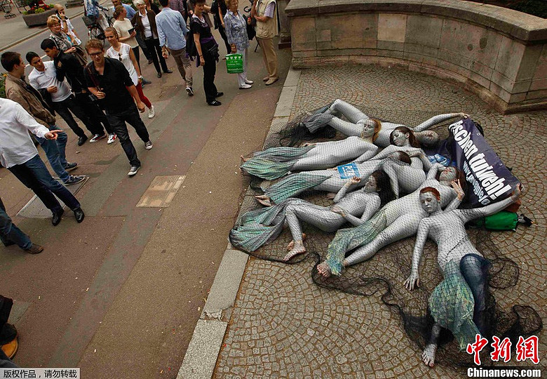 德国善待动物组织成员扮鱼钻渔网 抗议捕鱼-创