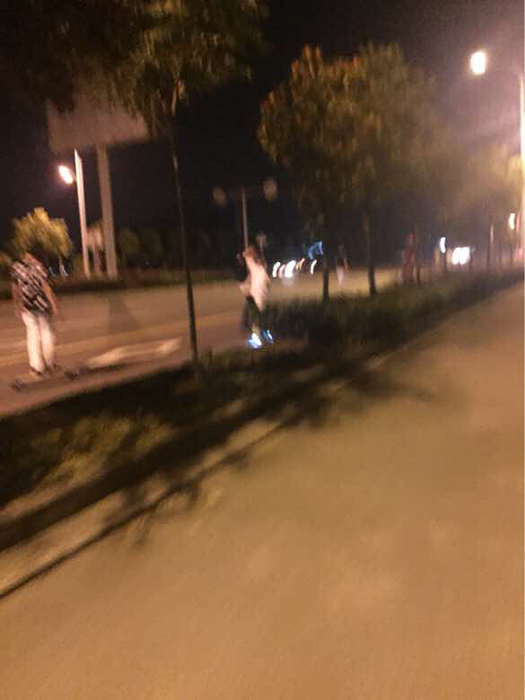 一群學(xué)生在機(jī)動車道玩滑板