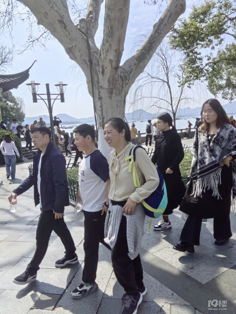 今天天氣太熱了，許多游客脫掉冬裝，穿上夏裝、短袖游西湖.