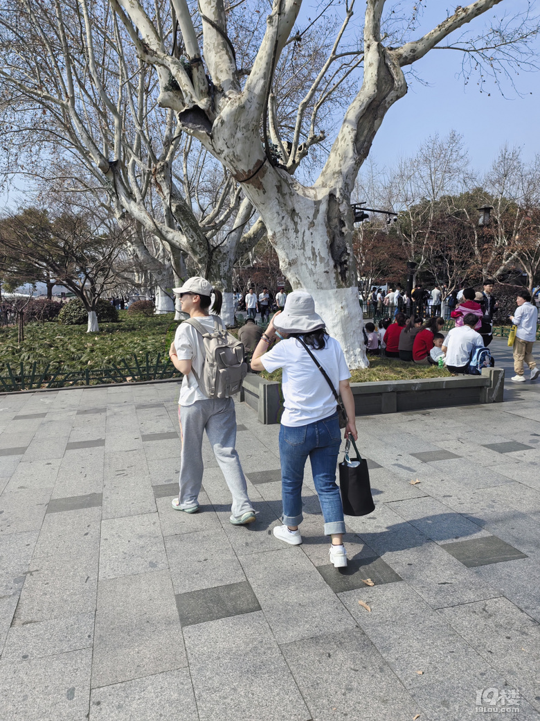 今天天氣太熱了，許多游客脫掉冬裝，穿上夏裝、短袖游西湖.