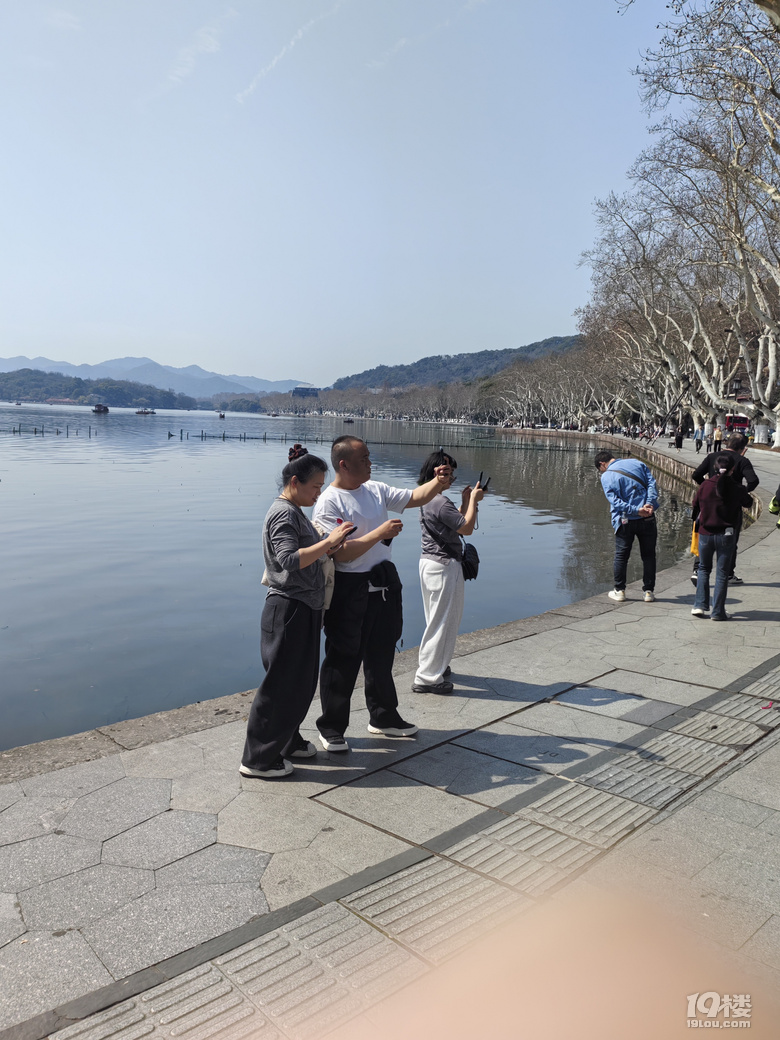 今天天氣太熱了，許多游客脫掉冬裝，穿上夏裝、短袖游西湖.