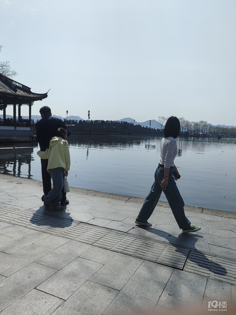 今天天氣太熱了，許多游客脫掉冬裝，穿上夏裝、短袖游西湖.