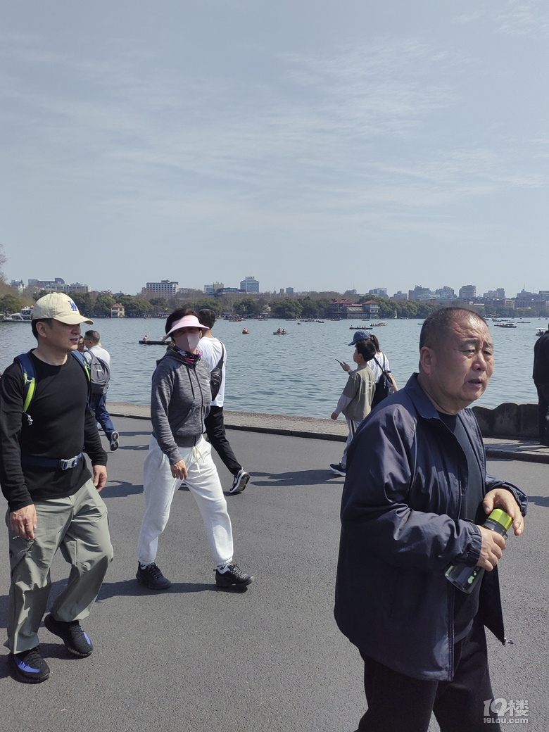 今天天氣太熱了，許多游客脫掉冬裝，穿上夏裝、短袖游西湖.
