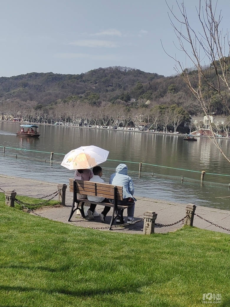 今天天氣太熱了，許多游客脫掉冬裝，穿上夏裝、短袖游西湖.
