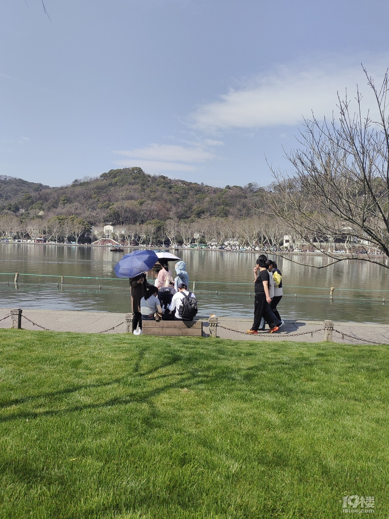 今天天氣太熱了，許多游客脫掉冬裝，穿上夏裝、短袖游西湖.