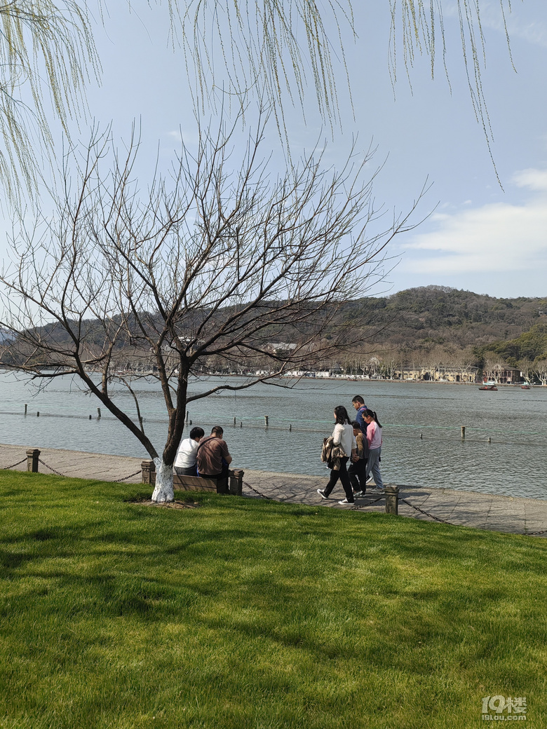 今天天氣太熱了，許多游客脫掉冬裝，穿上夏裝、短袖游西湖.