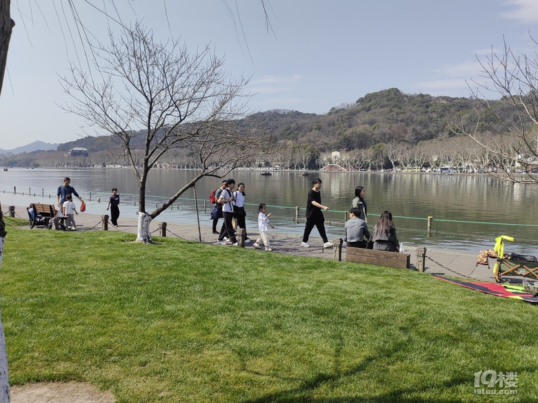 今天天氣太熱了，許多游客脫掉冬裝，穿上夏裝、短袖游西湖.