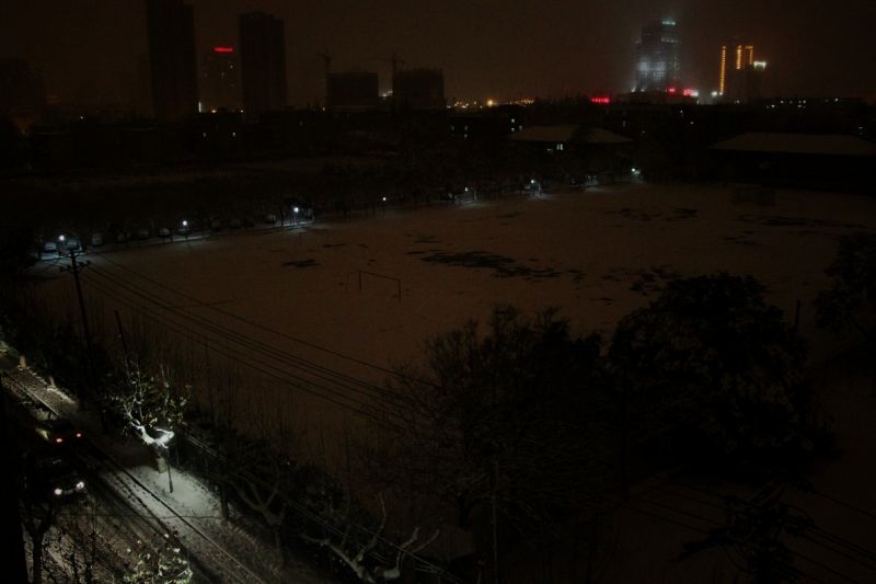 雪天的夜晚,清冷的农大操场,孤独的篮球架-边走