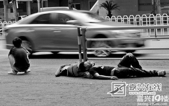 中山路非机动车道上 大白天躺着两个小伙子(图