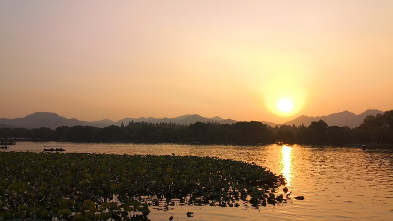 西湖向晚,日落月升,水波平