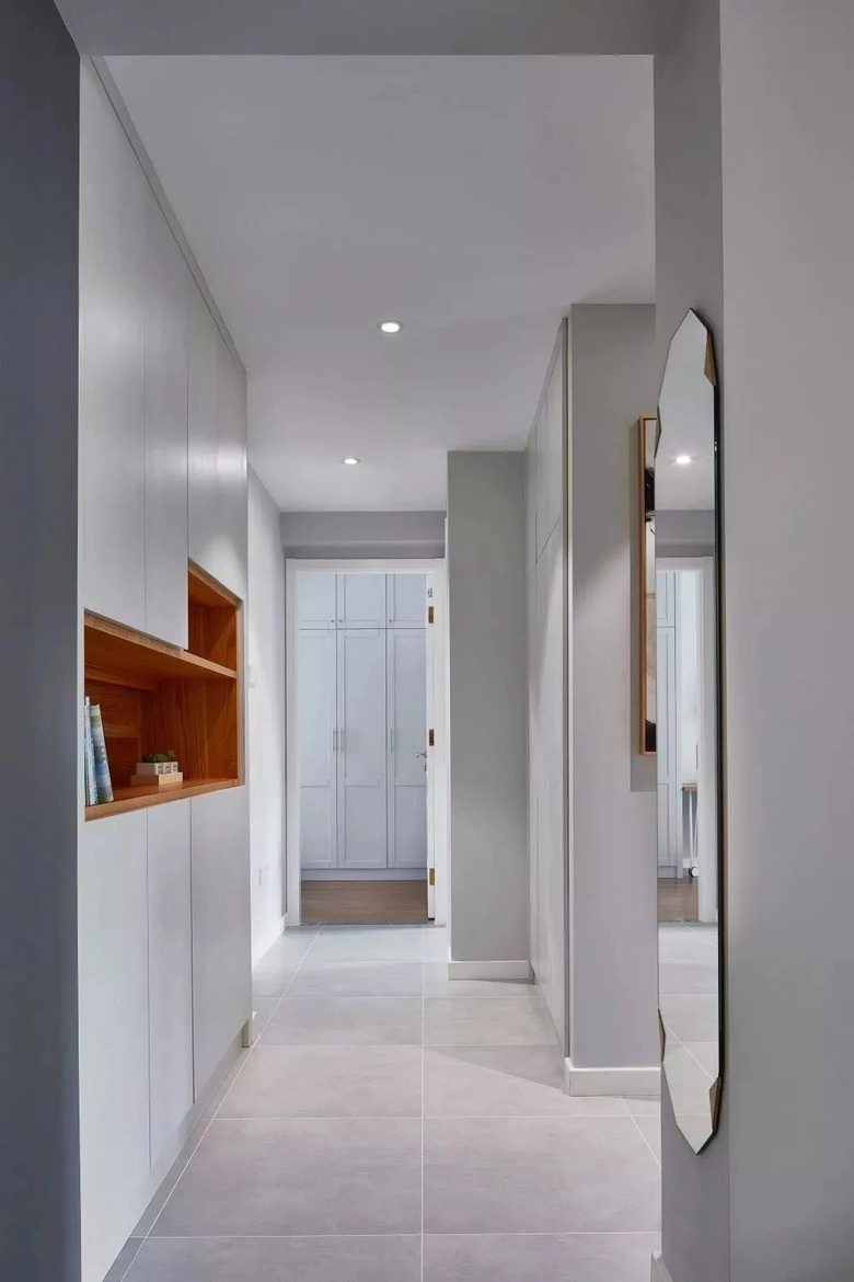 过道以内嵌柜展示,白色柜门 原木色镂空整齐有序,无形中增加了室内