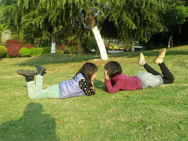 绿茵茵的草坪上俩个可爱的小精灵在尽情地玩耍